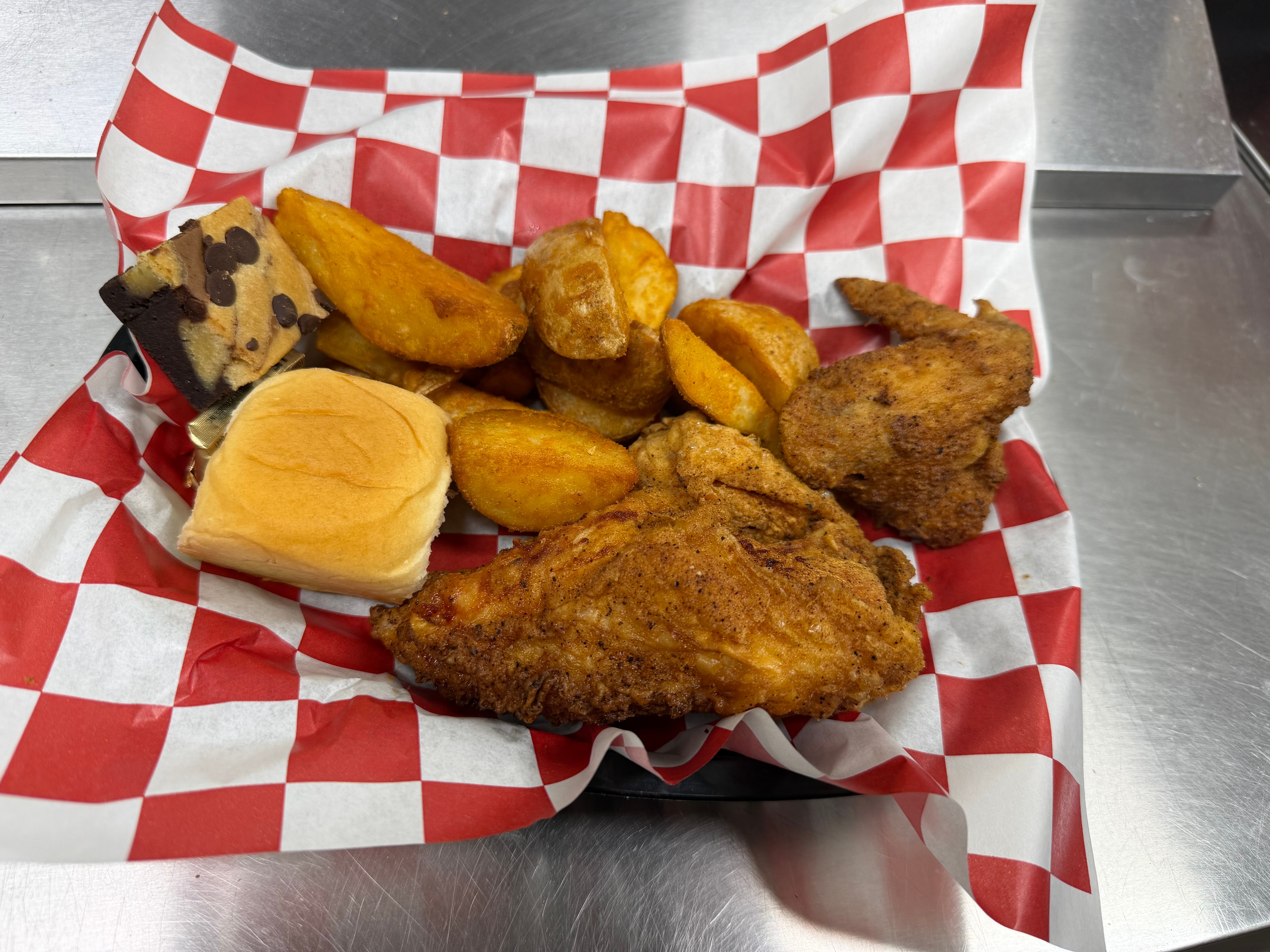 Broasted chicken with potato wedges and roll at Nina's