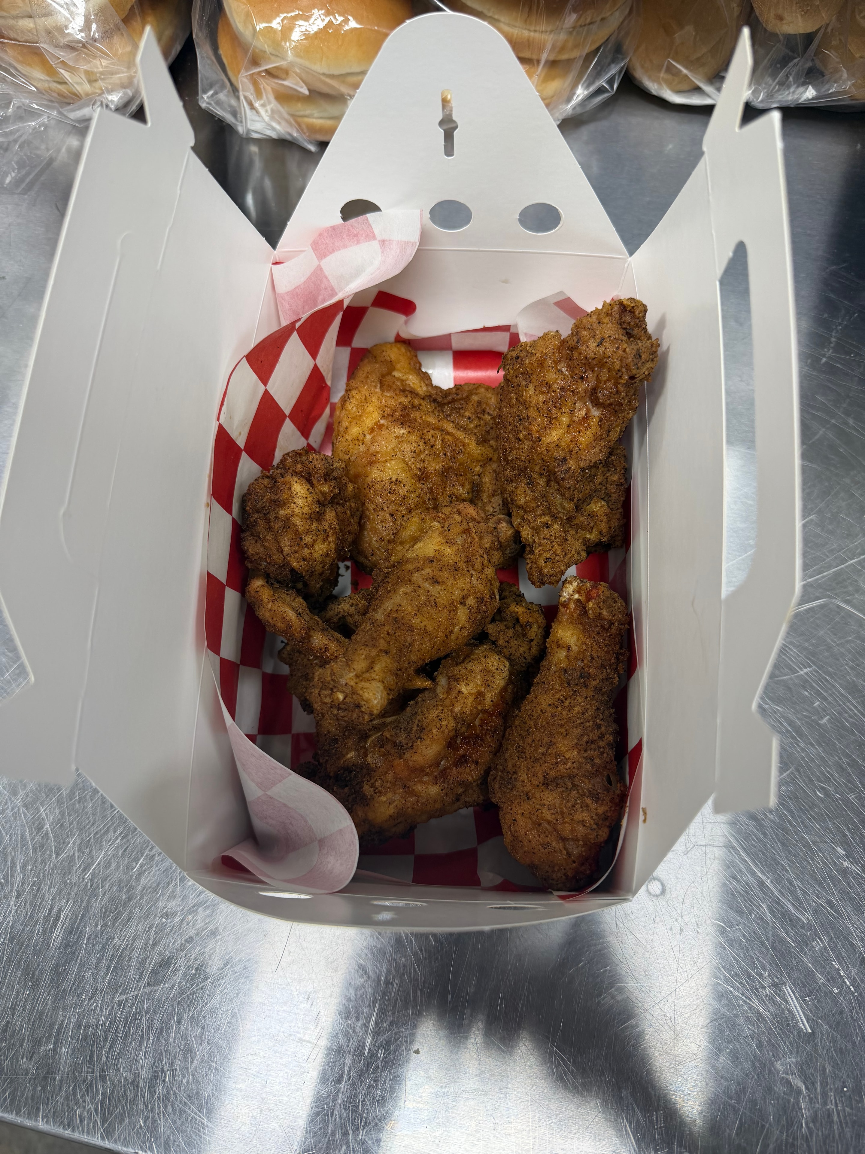 Broasted chicken pieces in takeout box at Nina's