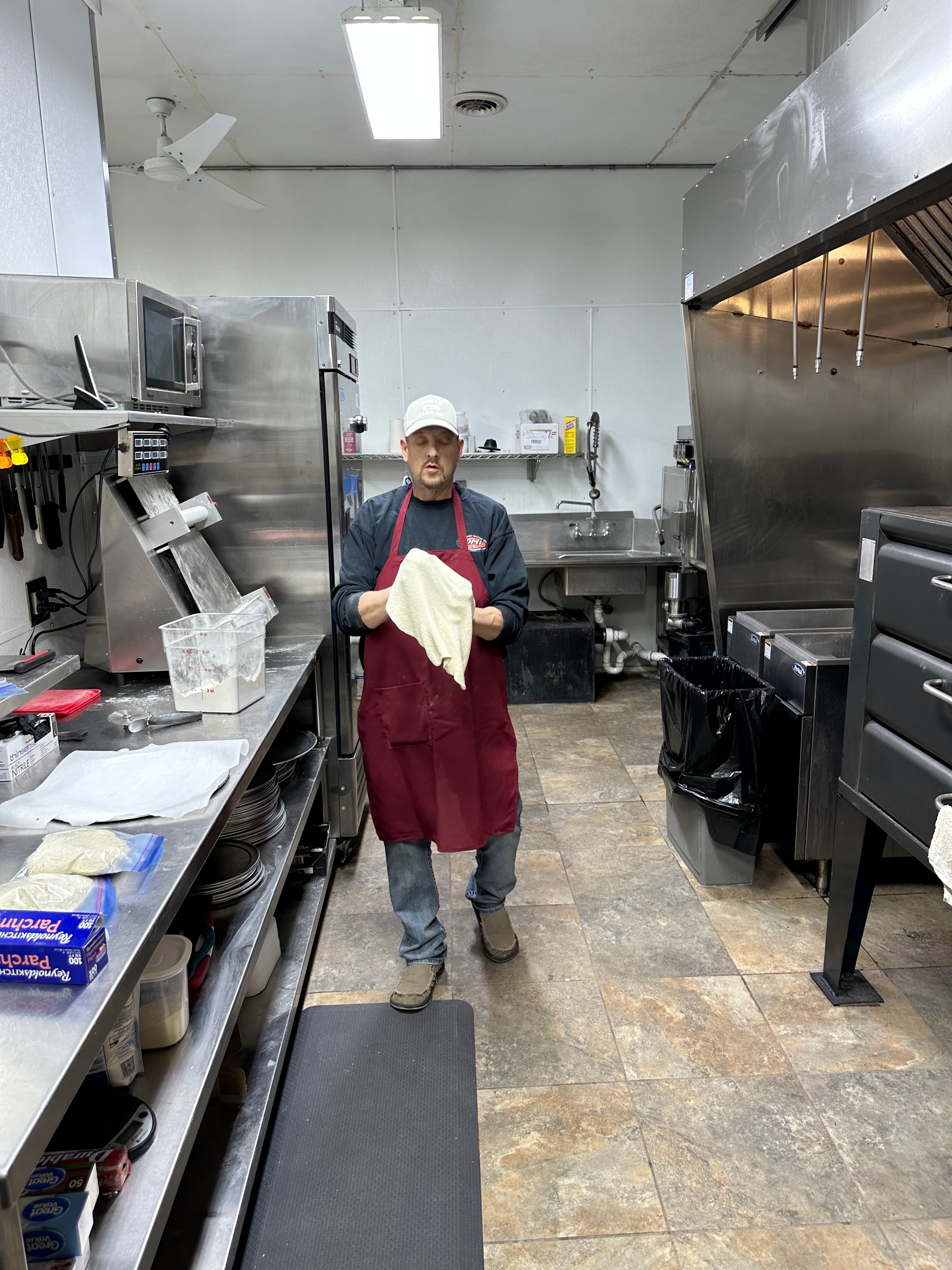 Chef in the kitchen at Nina's Pizza Shop